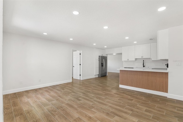 2817 Rheims Ave, Melbourne, FL 32935 - kitchen featuring stainless steel refrigerator with ice dispenser, open floor plan, light countertops, a peninsula, and recessed lighting
