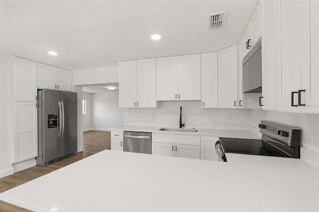 2817 Rheims Ave, Melbourne, FL 32935 - kitchen with appliances with stainless steel finishes, dark wood-type flooring, light countertops, and recessed lighting