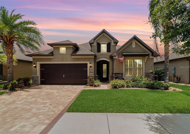 7814 SW 97th Cir, Ocala, FL 34481 - view of front of house with stucco siding, decorative driveway, a front lawn, an attached garage, and stone siding