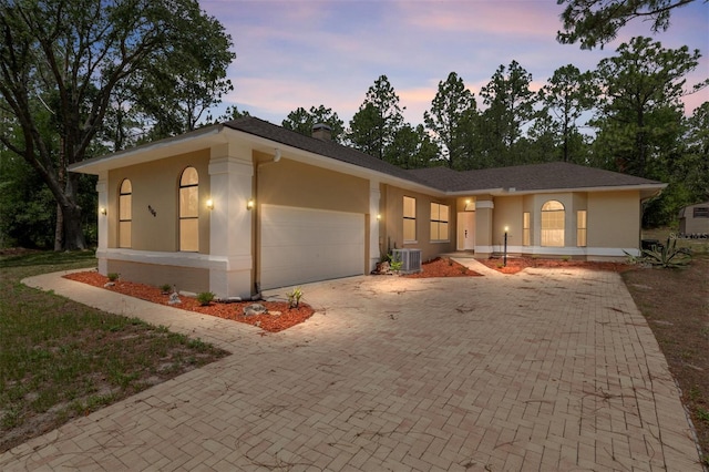 9180 SW 202nd Avenue Rd, Dunnellon, FL 34431 - ranch-style house featuring stucco siding, an attached garage, decorative driveway, and a chimney