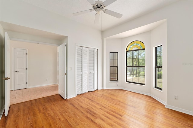 9180 SW 202nd Avenue Rd, Dunnellon, FL 34431 - unfurnished bedroom with light wood-style floors, a closet, and a ceiling fan