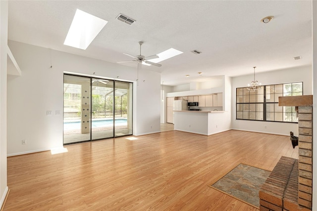 9180 SW 202nd Avenue Rd, Dunnellon, FL 34431 - unfurnished living room featuring a skylight, light wood-style flooring, a chandelier, and ceiling fan