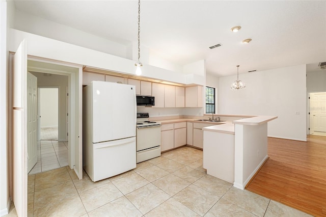 9180 SW 202nd Avenue Rd, Dunnellon, FL 34431 - kitchen featuring white appliances, a peninsula, light countertops, a chandelier, and hanging light fixtures