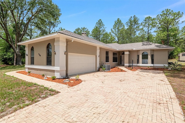 9180 SW 202nd Avenue Rd, Dunnellon, FL 34431 - ranch-style home with stucco siding, an attached garage, decorative driveway, a chimney, and roof with shingles