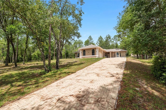 9180 SW 202nd Avenue Rd, Dunnellon, FL 34431 - view of front facade featuring decorative driveway, stucco siding, and a front lawn