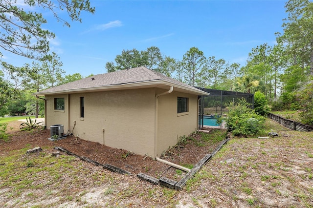9180 SW 202nd Avenue Rd, Dunnellon, FL 34431 - view of side of home featuring stucco siding, a swimming pool, and glass enclosure