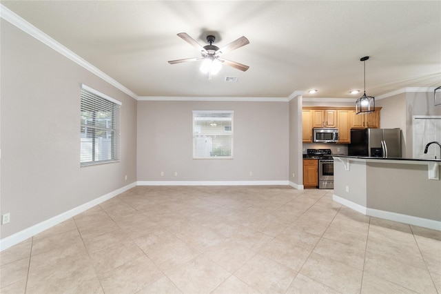 2127 NE 38th Ter, Ocala, FL 34470 - kitchen featuring appliances with stainless steel finishes, ornamental molding, dark countertops, ceiling fan, and pendant lighting