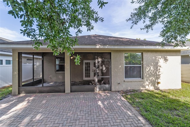 2127 NE 38th Ter, Ocala, FL 34470 - back of house with a sunroom, stucco siding, and a patio area