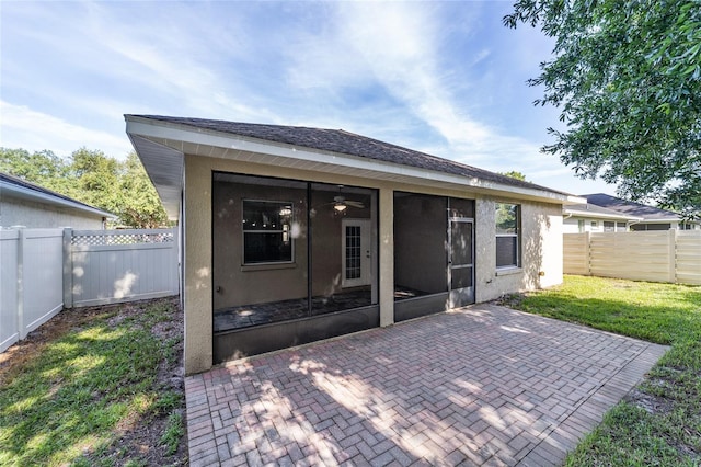 2127 NE 38th Ter, Ocala, FL 34470 - back of house featuring ceiling fan, a sunroom, a fenced backyard, a patio area, and stucco siding