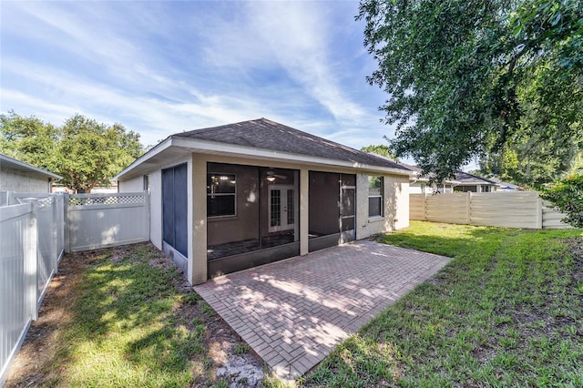 2127 NE 38th Ter, Ocala, FL 34470 - back of property featuring a sunroom, a fenced backyard, a patio area, french doors, and stucco siding