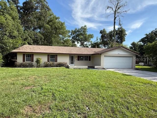 4701 NE 9th St, Ocala, FL 34470 - ranch-style house featuring a garage, concrete driveway, a front lawn, and stucco siding