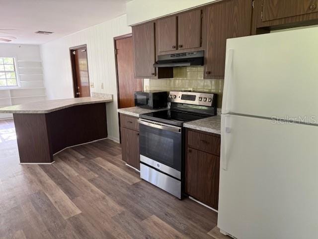 4701 NE 9th St, Ocala, FL 34470 - kitchen featuring freestanding refrigerator, stainless steel electric range, under cabinet range hood, light countertops, and tasteful backsplash