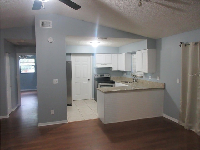 6141 NW 64th Ct, Ocala, FL 34482 - kitchen featuring under cabinet range hood, appliances with stainless steel finishes, a peninsula, white cabinetry, and light wood finished floors