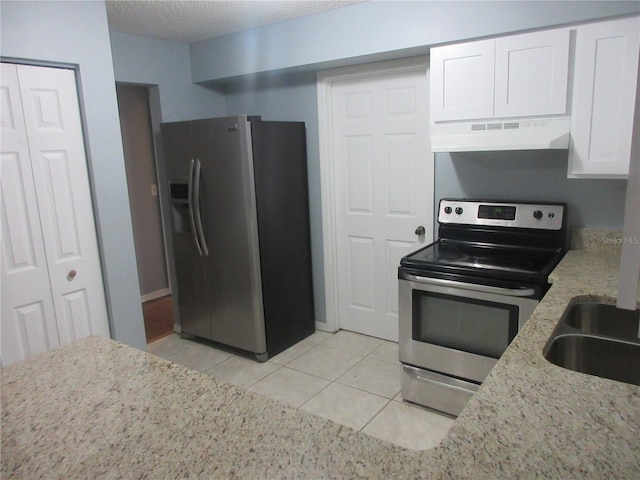 6141 NW 64th Ct, Ocala, FL 34482 - kitchen with stainless steel appliances, under cabinet range hood, white cabinets, light tile patterned floors, and light stone counters