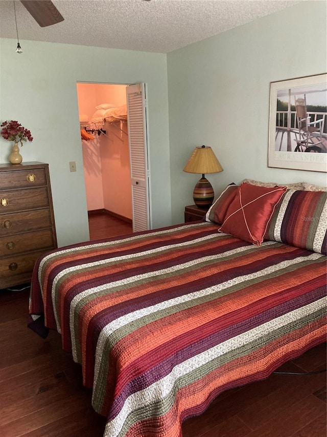 8450 SW 90th St Unit D, Ocala, FL 34481 - bedroom with hardwood / wood-style flooring, a textured ceiling, a spacious closet, and ceiling fan