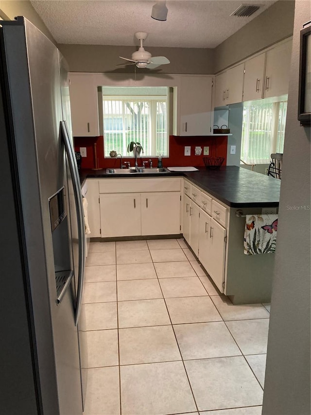 8450 SW 90th St Unit D, Ocala, FL 34481 - kitchen featuring stainless steel refrigerator with ice dispenser, dark countertops, light tile patterned flooring, healthy amount of natural light, and a textured ceiling