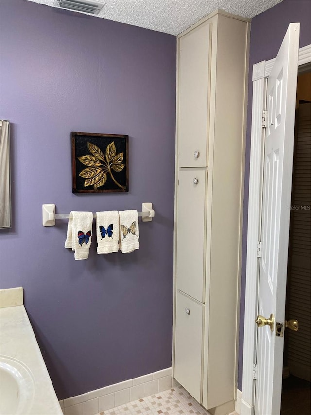 8450 SW 90th St Unit D, Ocala, FL 34481 - bathroom featuring vanity, a closet, and a textured ceiling