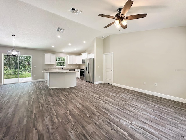3679 E Bernice St, Inverness, FL 34453 - kitchen featuring appliances with stainless steel finishes, open floor plan, dark wood-style flooring, a center island, and white cabinetry