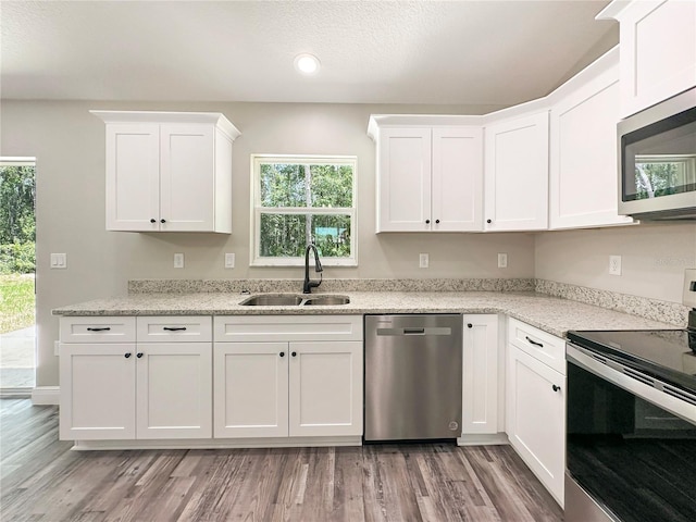 3679 E Bernice St, Inverness, FL 34453 - kitchen featuring stainless steel appliances, white cabinetry, light wood-style flooring, recessed lighting, and light stone counters