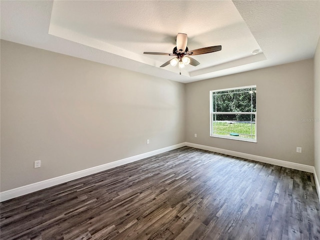 3679 E Bernice St, Inverness, FL 34453 - empty room featuring a tray ceiling, dark wood finished floors, and ceiling fan