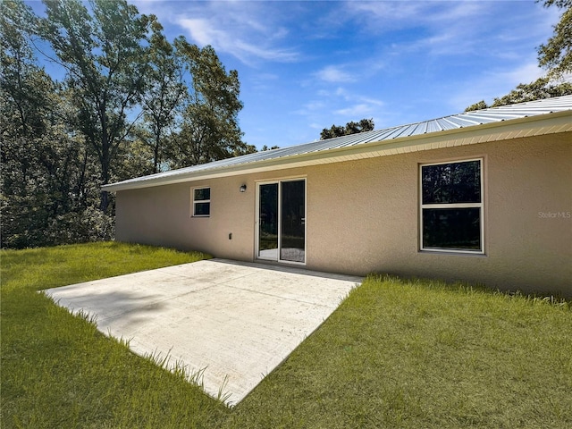 3679 E Bernice St, Inverness, FL 34453 - rear view of property featuring stucco siding, a patio, a lawn, and a metal roof