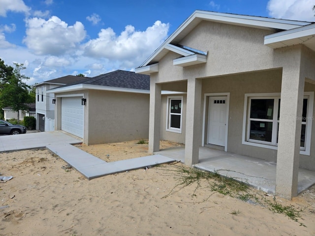 11139 N Sonnet Ter, Citrus Springs, FL 34433 - view of property exterior with stucco siding, an attached garage, and a shingled roof