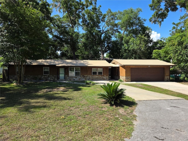 315 NE 2nd Ave, Williston, FL 32696 - ranch-style home with stone siding, driveway, a front yard, and an attached garage