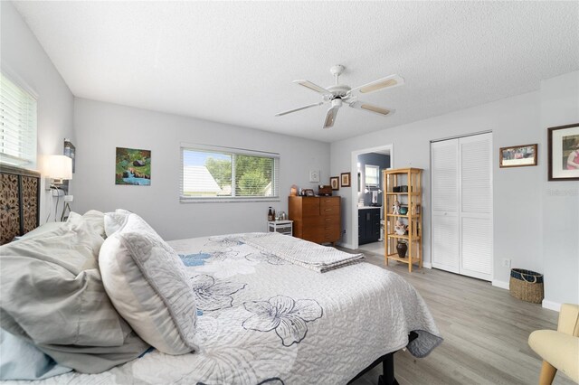 8841 SW 91st St Unit A, Ocala, FL 34481 - bedroom featuring wood finished floors, a closet, a textured ceiling, ceiling fan, and connected bathroom