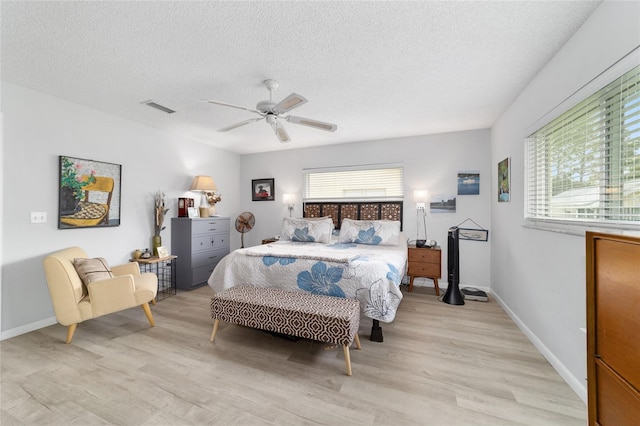 8841 SW 91st St Unit A, Ocala, FL 34481 - bedroom with light wood-style flooring, a textured ceiling, and a ceiling fan
