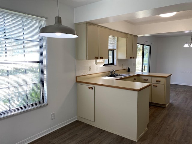 3381 NW 44th Ct, Ocala, FL 34482 - kitchen with a peninsula, dark wood-style flooring, light countertops, and hanging light fixtures
