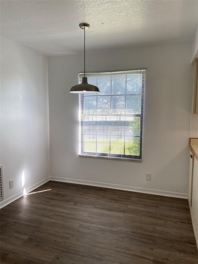 3381 NW 44th Ct, Ocala, FL 34482 - unfurnished dining area featuring dark wood-style flooring and a textured ceiling