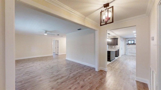 4121 SW 6th Ave, Ocala, FL 34471 - empty room featuring light wood finished floors, ornamental molding, ceiling fan, and a chandelier