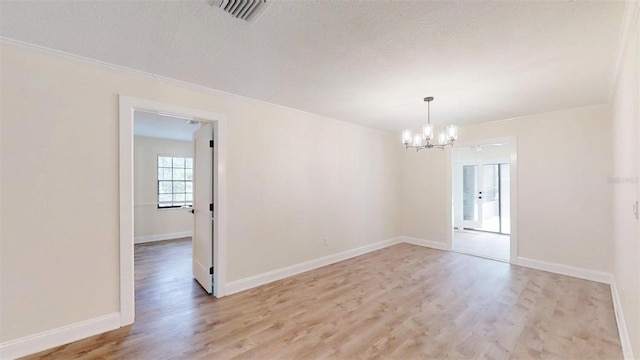4121 SW 6th Ave, Ocala, FL 34471 - empty room featuring a chandelier, light wood-style floors, crown molding, and a textured ceiling