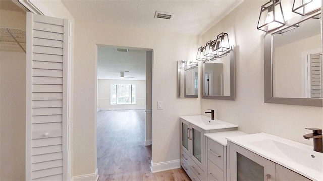 4121 SW 6th Ave, Ocala, FL 34471 - bathroom featuring wood finished floors, two vanities, and ceiling fan