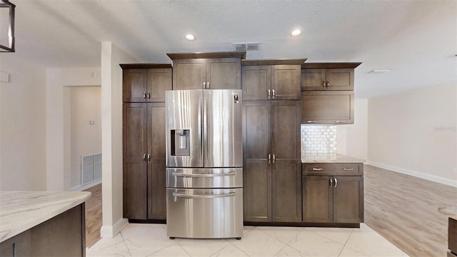 4121 SW 6th Ave, Ocala, FL 34471 - kitchen featuring stainless steel fridge, light stone counters, recessed lighting, dark brown cabinets, and light marble finish flooring
