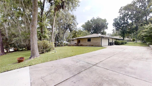 4121 SW 6th Ave, Ocala, FL 34471 - view of side of home with a garage, a lawn, driveway, and brick siding