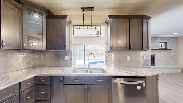 4121 SW 6th Ave, Ocala, FL 34471 - kitchen with stainless steel dishwasher, dark brown cabinetry, light stone counters, and backsplash