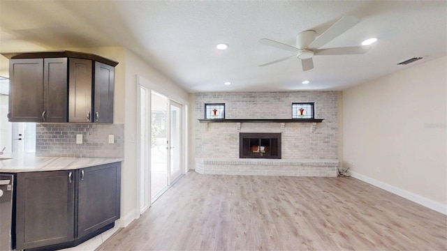 4121 SW 6th Ave, Ocala, FL 34471 - unfurnished living room with a ceiling fan, light wood-style floors, a brick fireplace, and recessed lighting