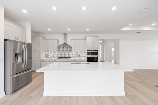 10032 SW 85th Place Rd, Ocala, FL 34481 - kitchen with stainless steel fridge with ice dispenser, wall chimney range hood, cooktop, double oven, and light wood-type flooring