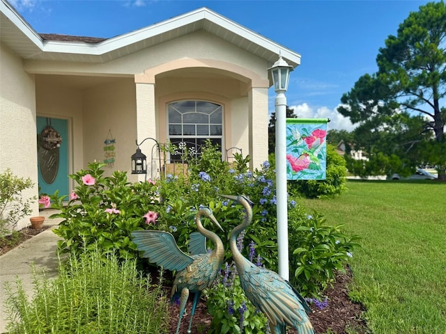 1824 W Zoe Ct, Lecanto, FL 34461 - view of exterior entry featuring stucco siding and a yard