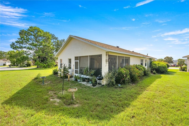 1824 W Zoe Ct, Lecanto, FL 34461 - view of property exterior featuring stucco siding, a lawn, and a sunroom