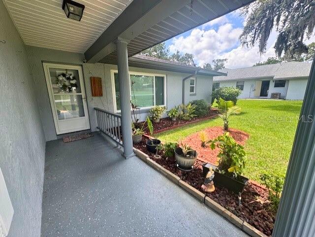 916 Jones Ave, Inverness, FL 34453 - property entrance featuring a lawn and stucco siding