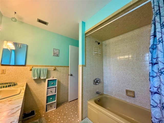 916 Jones Ave, Inverness, FL 34453 - bathroom with shower / tub combo, tile walls, vanity, and wainscoting