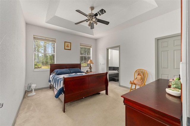 12320 SW 62nd Pl, Ocala, FL 34481 - bedroom featuring light carpet, a tray ceiling, ceiling fan, and ensuite bathroom