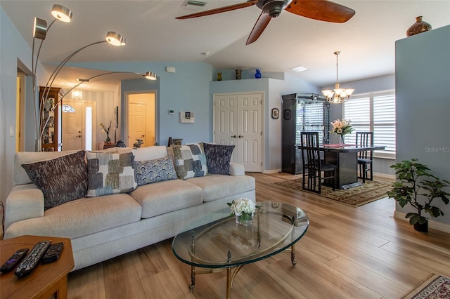 1768 SW 156th Ln, Ocala, FL 34473 - living area with a ceiling fan, arched walkways, light wood-type flooring, vaulted ceiling, and a chandelier
