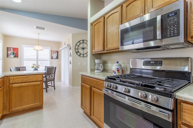 1768 SW 156th Ln, Ocala, FL 34473 - kitchen featuring stainless steel appliances, light countertops, light tile patterned flooring, pendant lighting, and brown cabinets