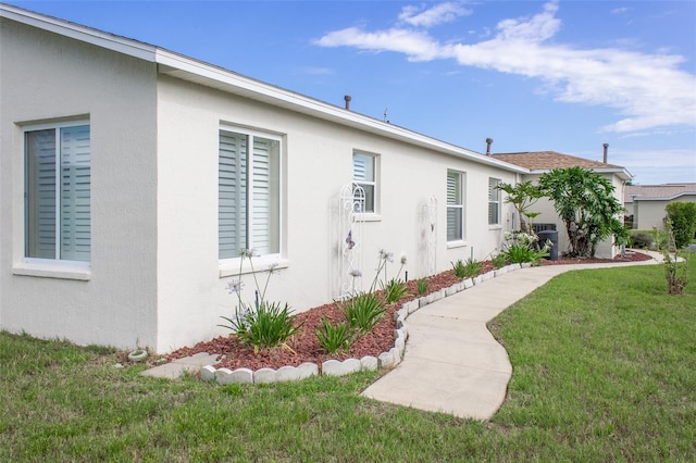 1768 SW 156th Ln, Ocala, FL 34473 - view of side of home with stucco siding and a lawn
