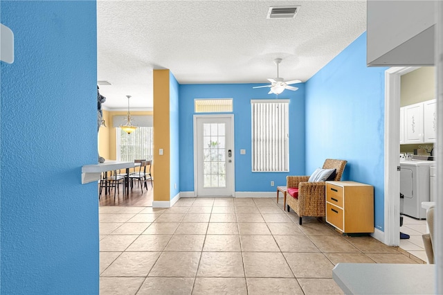 6551 SE 11th Loop, Ocala, FL 34472 - foyer entrance featuring washing machine and clothes dryer, light tile patterned floors, ceiling fan, and a textured ceiling
