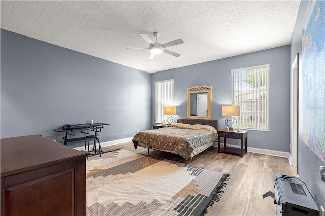 6551 SE 11th Loop, Ocala, FL 34472 - bedroom with light wood finished floors, a textured ceiling, and ceiling fan