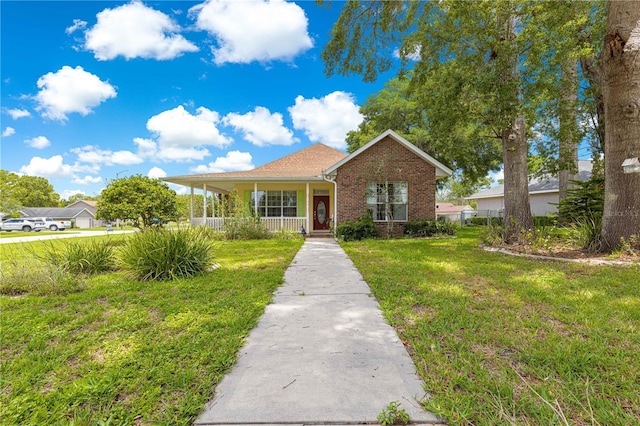 6551 SE 11th Loop, Ocala, FL 34472 - view of front facade with a front yard, brick siding, and a porch